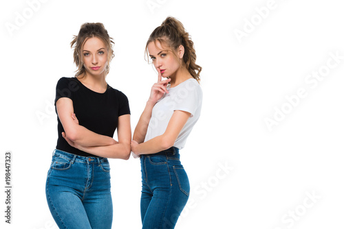 confident attractive young twins looking at camera isolated on white