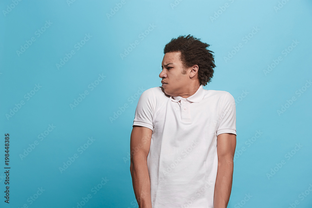 Let me think. Doubtful pensive man with thoughtful expression making choice against blue background Let me think. Doubtful pensive man with thoughtful expression making choice against blue background