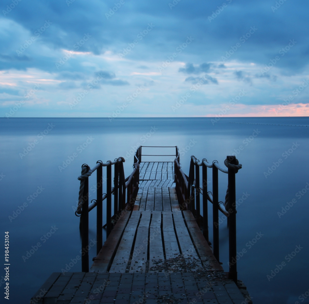 Blue romantic landscape with pier and sea