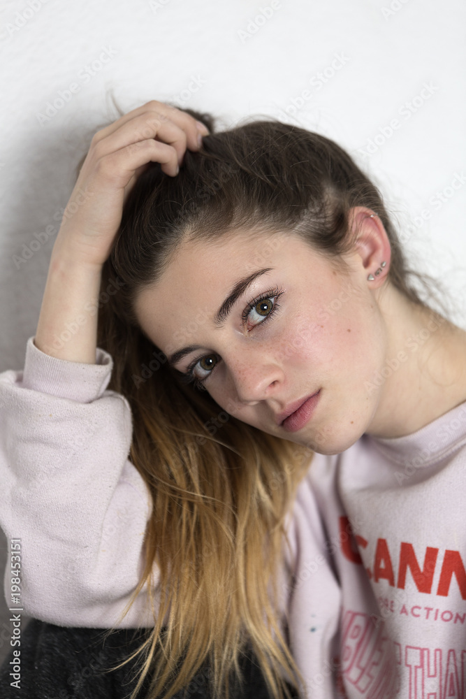 Young woman looking at camera with serious face. Vertical shot with natural light