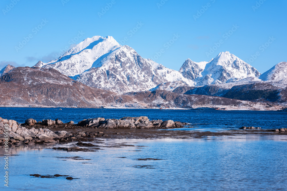 Scenery winter landscape in the Norway, wild northern nature. Rocky mountains with sea coast and serene blue sky, Lofoten Islands, Napp, Flakstad
