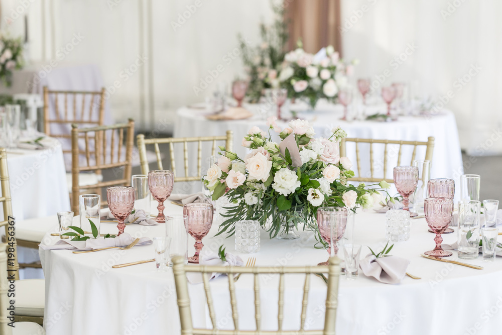 Beautiful table setting with crockery and flowers for a party, wedding reception or other festive event. Glassware and cutlery for catered event dinner. - obrazy, fototapety, plakaty 