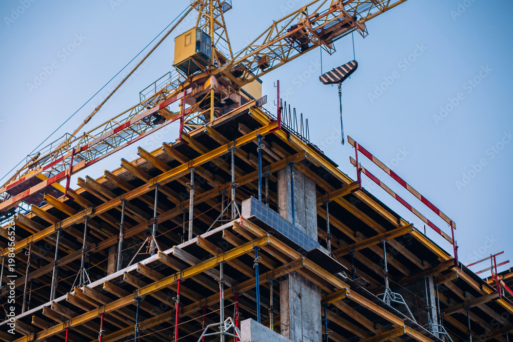 Crane and building construction site on background of  sky. Industrial landscape with silhouettes of cranes and building over sunlight. space for text . steel and concrete . development