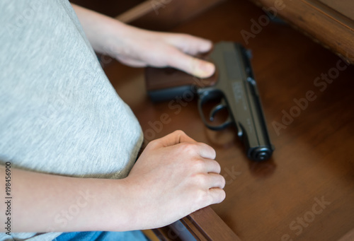Bild auf Leinwand Child found pistol in drawer at home.