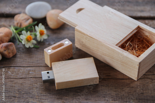 Wood usb flash drive with wooden box on rustic wood floor and decorate with flower and stone. ecology concept.
