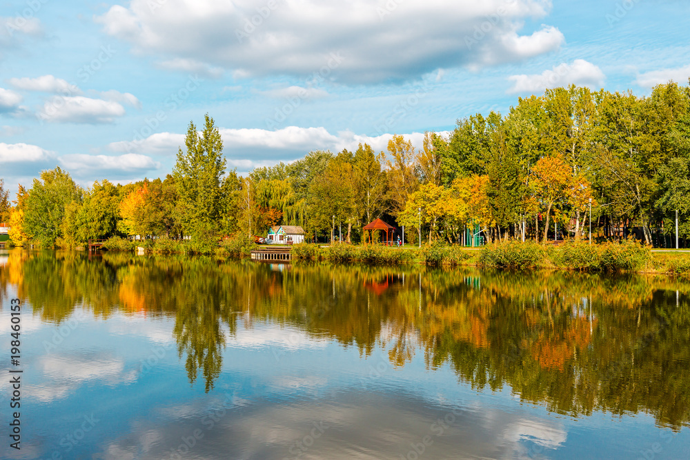 Beautiful lake with mirror reflections in clear water on sunny day.  Tranquil landscape with lake, cloudy sky, and trees reflected symmetrically  in the water. Salt lake (Sosto) Nyiregyhaza, Hungary Stock Photo