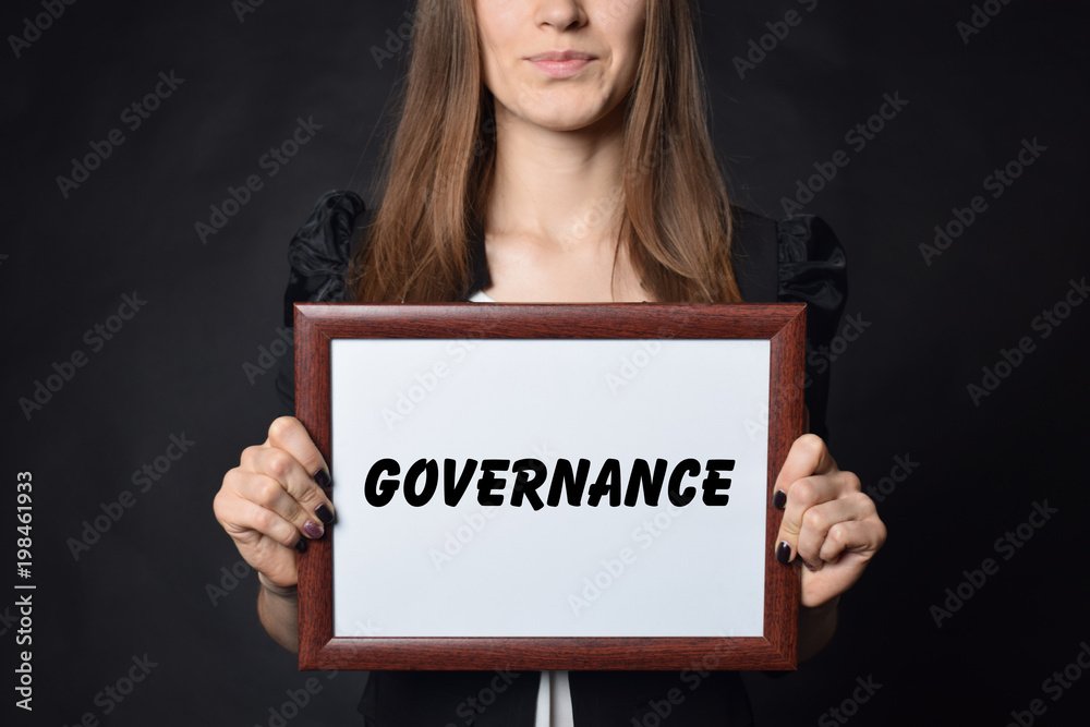 In the hands of a businessman a frame with the inscription:GOVERNANCE