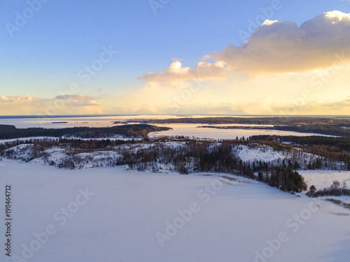 Aerial drone view of a winter landscape. Snow covered forest and lakes from the top. Sunrise in nature from a birds eye view. Aerial photography. Aerial photo. Quadcopter.