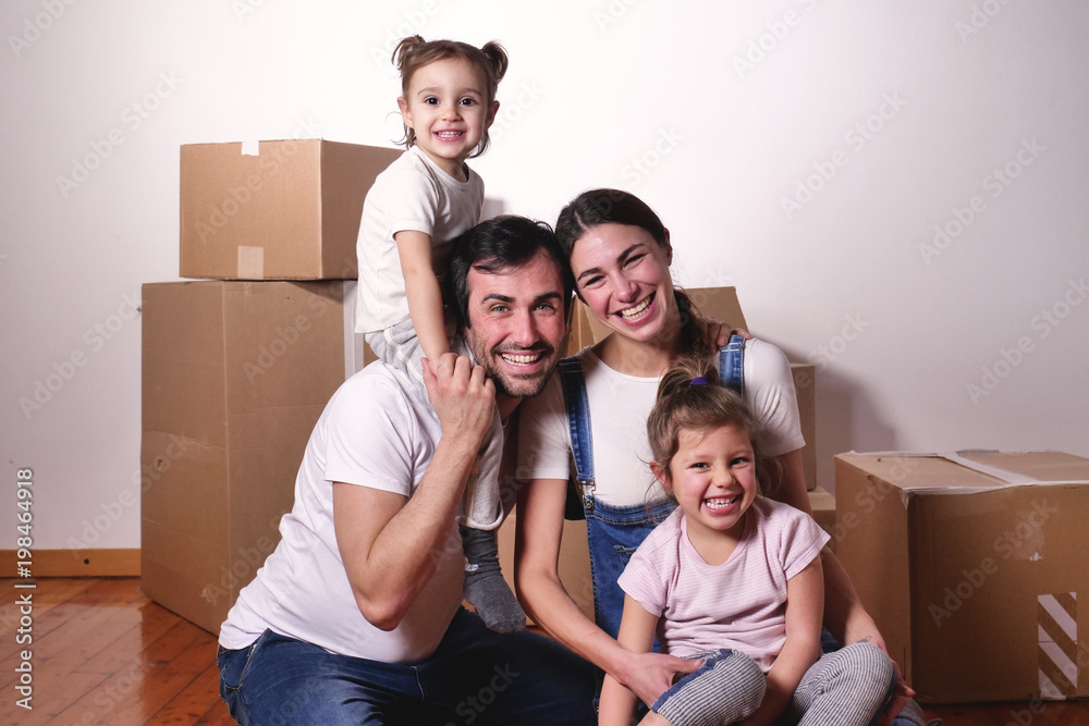 Portrait of a beautiful happy and smiling family just arrived in the new house to start a new journey together. Concept of: love, family, home. Portrait of a beautiful happy and smiling family just arrived in the new house to start a new journey together. Concept of: love, family, home.