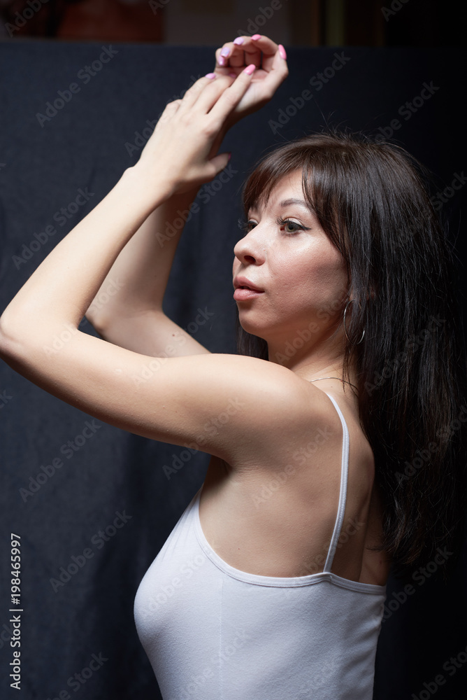 Obraz premium Sexy curvy brunette in white body on a black background