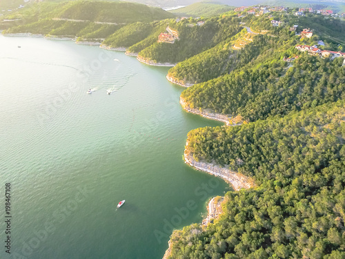 Aerial trees and cliff rock wall, bluffs at Lake Travis, Austin, Texas, USA. Luxury vacation homes and house on coastline. Looking down houses in community, ocean crystal background photo