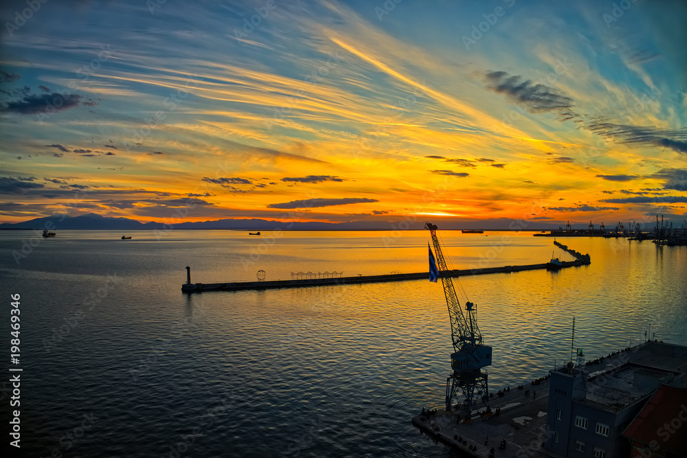 explosion of colors from the sunset above the harbor in the city of Thessaloniki, Greece