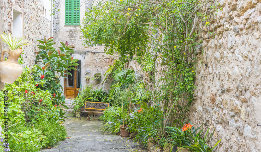 Beautiful street in Valldemossa with traditional flower decoration, famous old mediterranean village of Majorca. Balearic island Mallorca, Spain