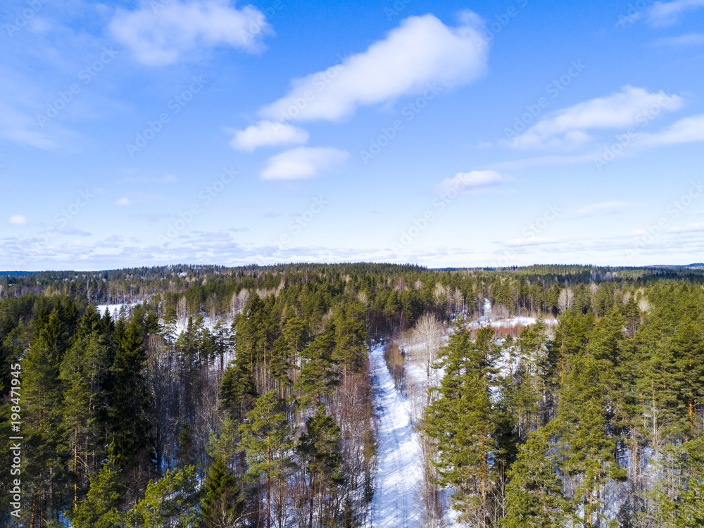 Aerial view of a winter road. Winter landscape countryside. Aerial photography of snow forest. Captured from above with a drone. Aerial photography. Nature from a birds eye view. Qadcopter.