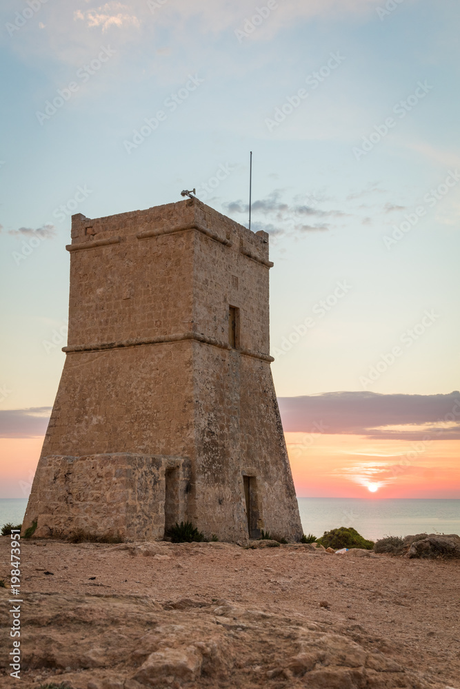 Beautiful golden sunset at Ghajn Tuffieha Tower, above Golden Bay, ancient watchtower built by the Knights of St. John, Golden Bay, Malta