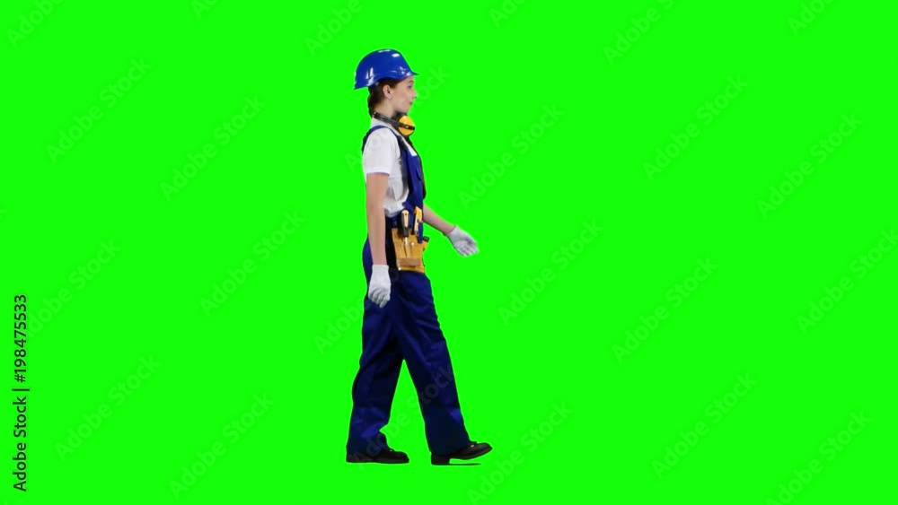 Girl is walking in a helmet to work. Green screen. Side view Girl is walking in a helmet to work. Green screen. Side view