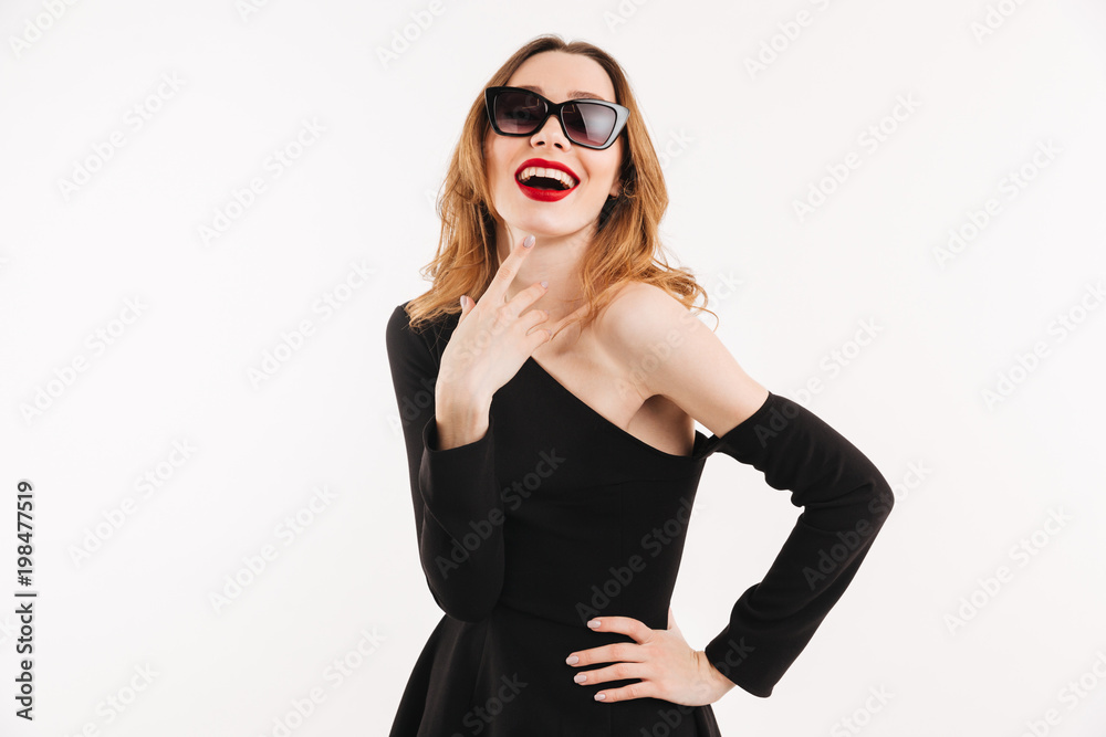 Pleased woman in dress and sunglasses holding arm on hip Pleased woman in dress and sunglasses holding arm on hip