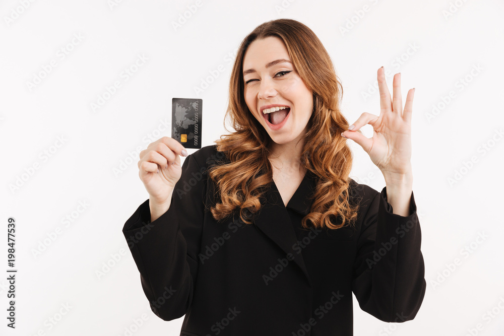 Cheerful elegant woman in coat holding credit card