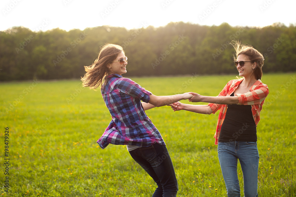 Two girls dancing outdoors. Spending time in nature. Two girls dancing outdoors. Spending time in nature.