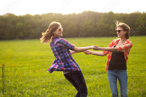 Two girls dancing outdoors. Spending time in nature.