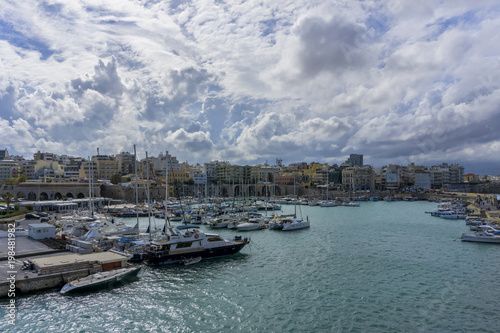 Heraklion, Crete Island - Greece. Panoramic view of Heraklion city, from the Venetian fortress "Koules" (castello a mare). Traditional fishing boats, yachts are docked at the old port of the city.  © isandro75