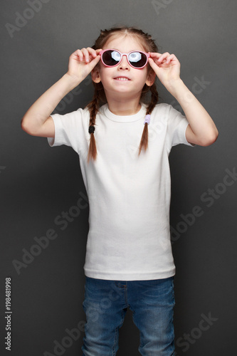 Kid girl wearing white t-shirt with space for your logo or design in casual urban style