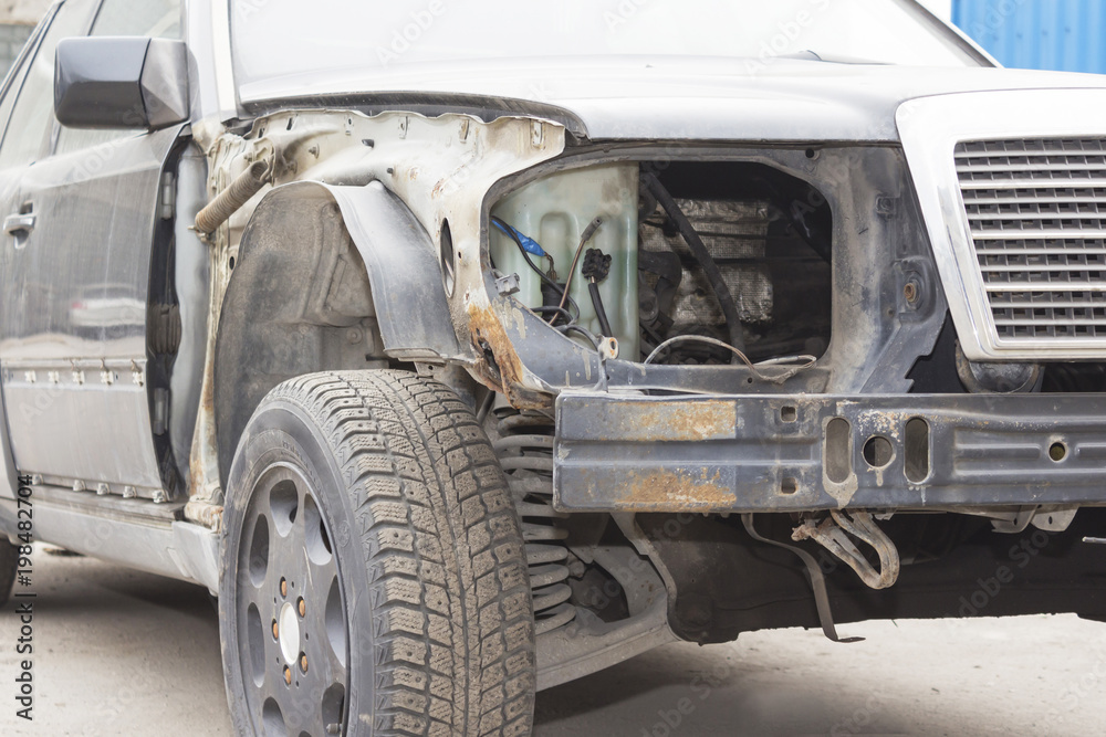 Color image of a crashed car with broken headlight.