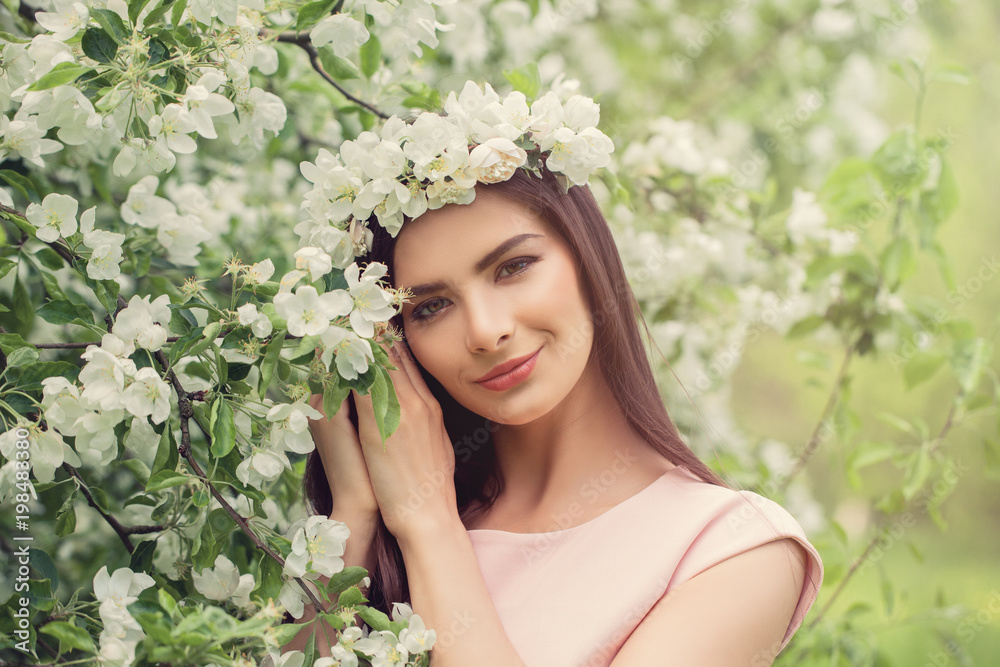 Beautiful young woman in blossom spring flowers garden background Beautiful young woman in blossom spring flowers garden background