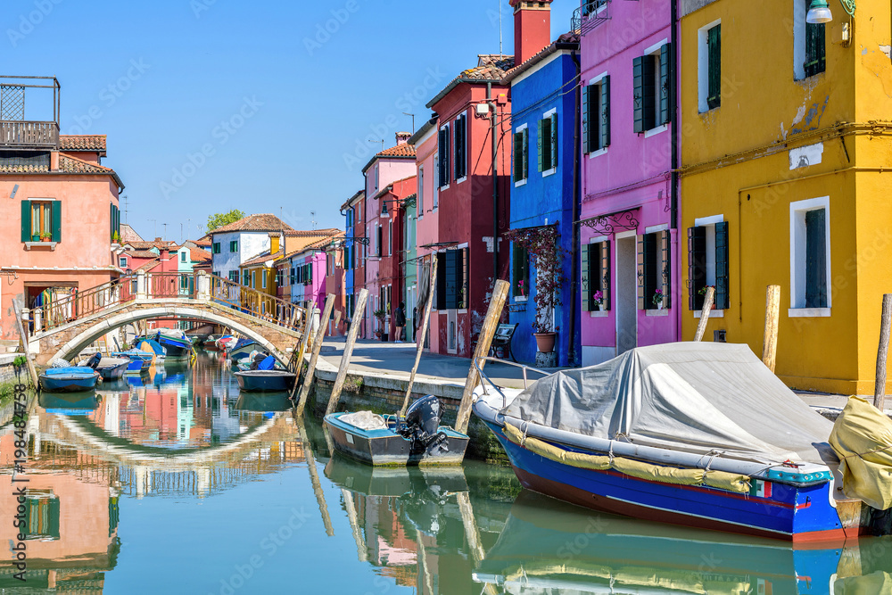 Daylight view to parked boats in a canal with image reflecting