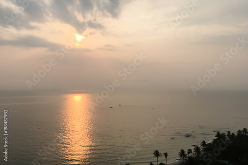 Dramatic atmosphere panorama view of golden sunrise sky and clouds with the reflection on the ocean and the beach.