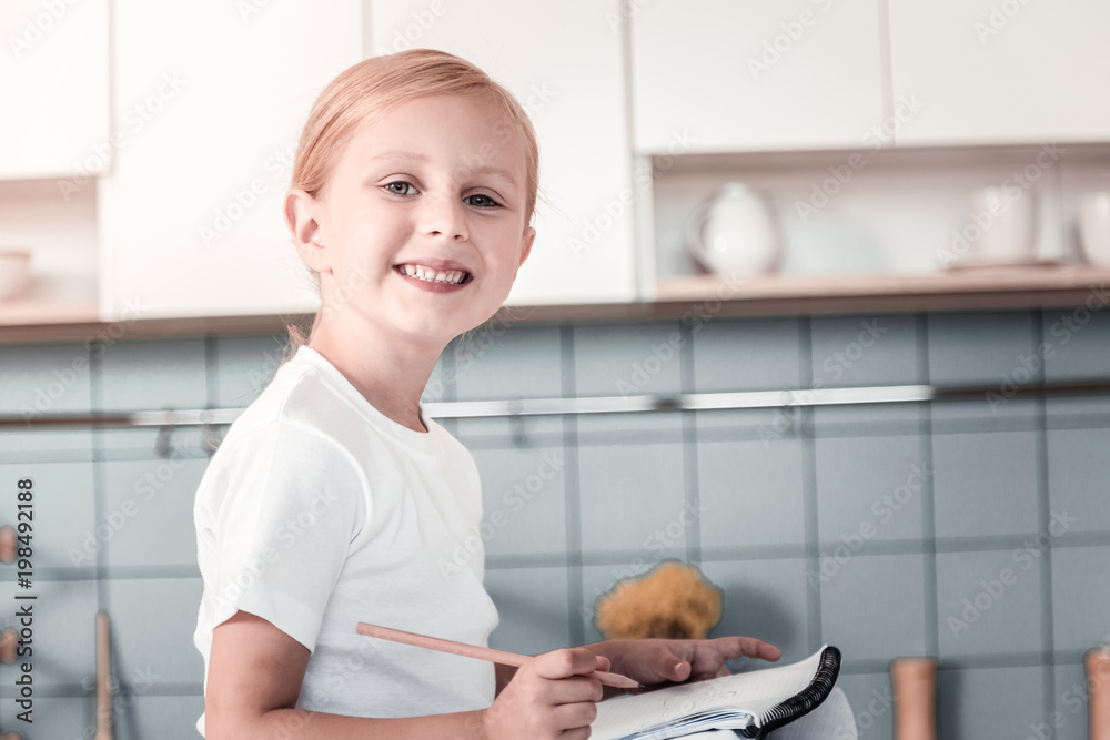 Pleasant smile. Cheerful girl expressing positivity while drawing picture and having good mood Pleasant smile. Cheerful girl expressing positivity while drawing picture and having good mood