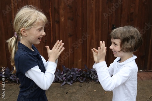 Bilde på lerret Two girls playing pat a cake