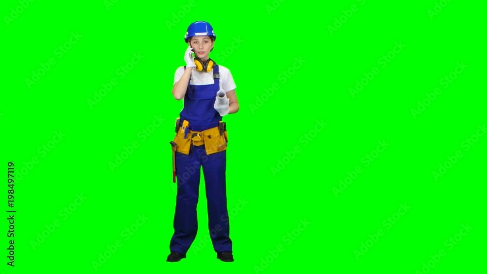 Architect is standing and talking on the phone with a drawing in her hands. Green screen Architect is standing and talking on the phone with a drawing in her hands. Green screen
