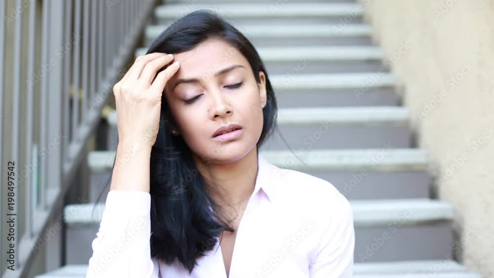 Closeup portrait, sad young woman in pink shirt sitting on stairs, really depressed, down about something, isolated outdoors stairs background. Negative emotion facial expression feeling reaction