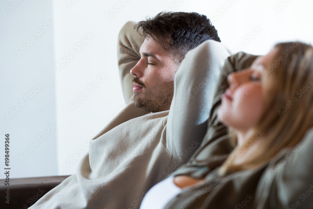 Beautiful young relaxed couple sleeping on the sofa at home. Beautiful young relaxed couple sleeping on the sofa at home.