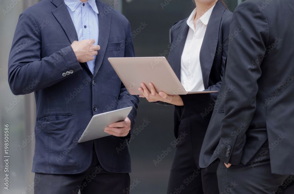 group of business people in suit talking and reading information about finance news in laptop computer together standing in modern city, network technology, internet, successful, teamwork concept group of business people in suit talking and reading information about finance news in laptop computer together standing in modern city, network technology, internet, successful, teamwork concept