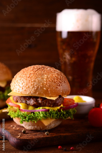 Fresh burger closeup and beer. Wooden rustic background. Top view