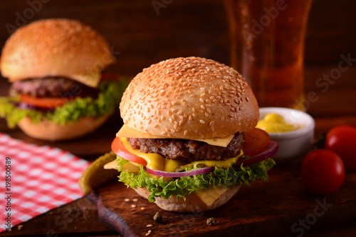 Fresh burger closeup and beer. Wooden rustic background. Top view