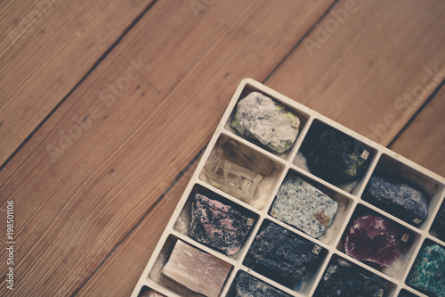 Collection of minerals in box on wooden background © natalialeb