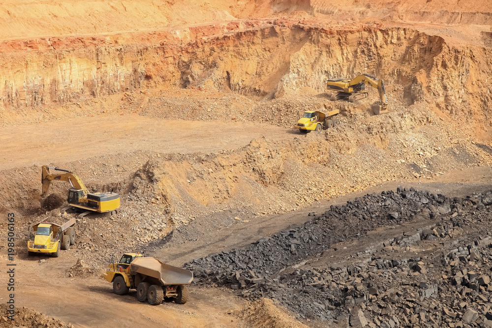 Open pit Manganese Mining - Excavators digging out ore rich rock and loading it onto rock dump trucks for processing Open pit Manganese Mining - Excavators digging out ore rich rock and loading it onto rock dump trucks for processing