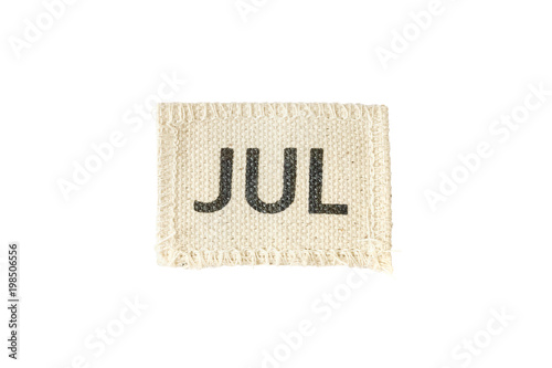 Closeup small picec of fabric calendar in july month isolated on white background
