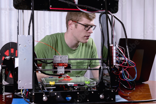 Young man using a 3D printer