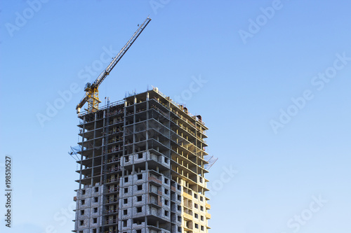 Modern multi-storey building in the city on the shore on blue sky background