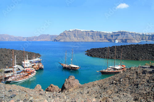 Tourist excursion boats at small port on volcano of Santorini
