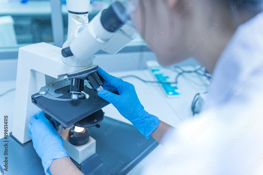 Young asian scientist looking through a microscope in a laboratory.Thailand people doing some research. Young asian scientist looking through a microscope in a laboratory.Thailand people doing some research.