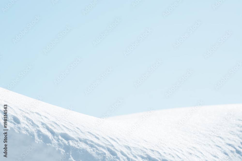 Fresh snow background texture. Winter background with snowflakes and snow mounds. Blue sky