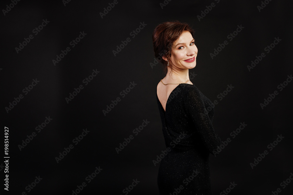Fototapeta premium Elegance woman in black evening dress posed on studio isolated on black.