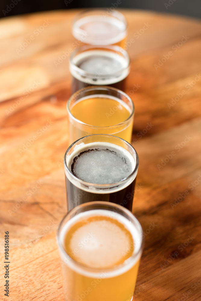 Overhead on a stout beer with a tasting flight arranged in a straight row Overhead on a stout beer with a tasting flight arranged in a straight row