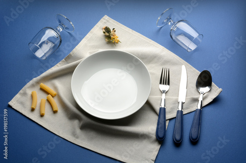 plate, fork, glasses on the blue table