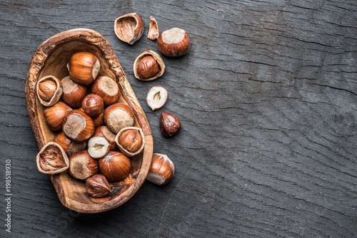 Filberts or hazelnuts in the wooden bowl on the table.